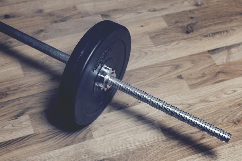 Un bilanciere sul pavimento di legno di una palestra